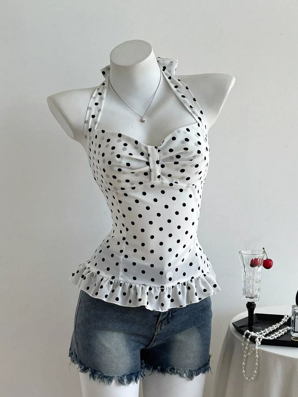 Polka dot halter neck cami with fitted bodice and ruffled waist peplum