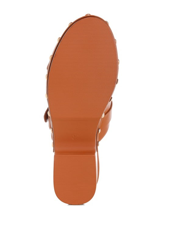 Tan clog outsole view with textured tread and studded side edges
