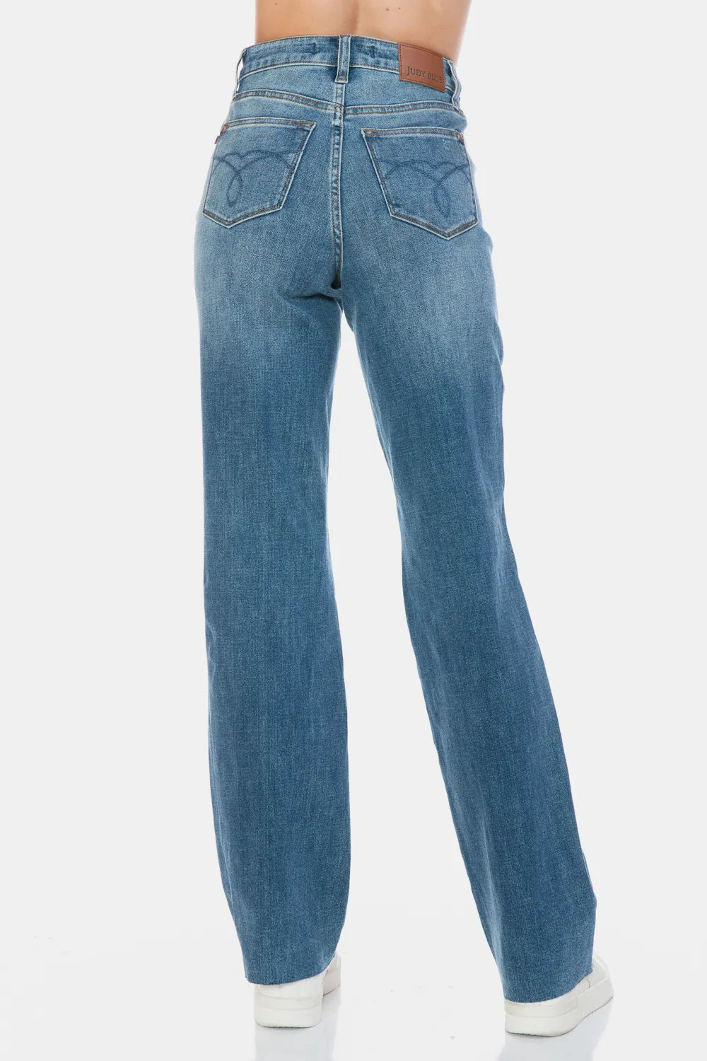 Medium-wash straight jeans back view with rear patch pockets and raw hem