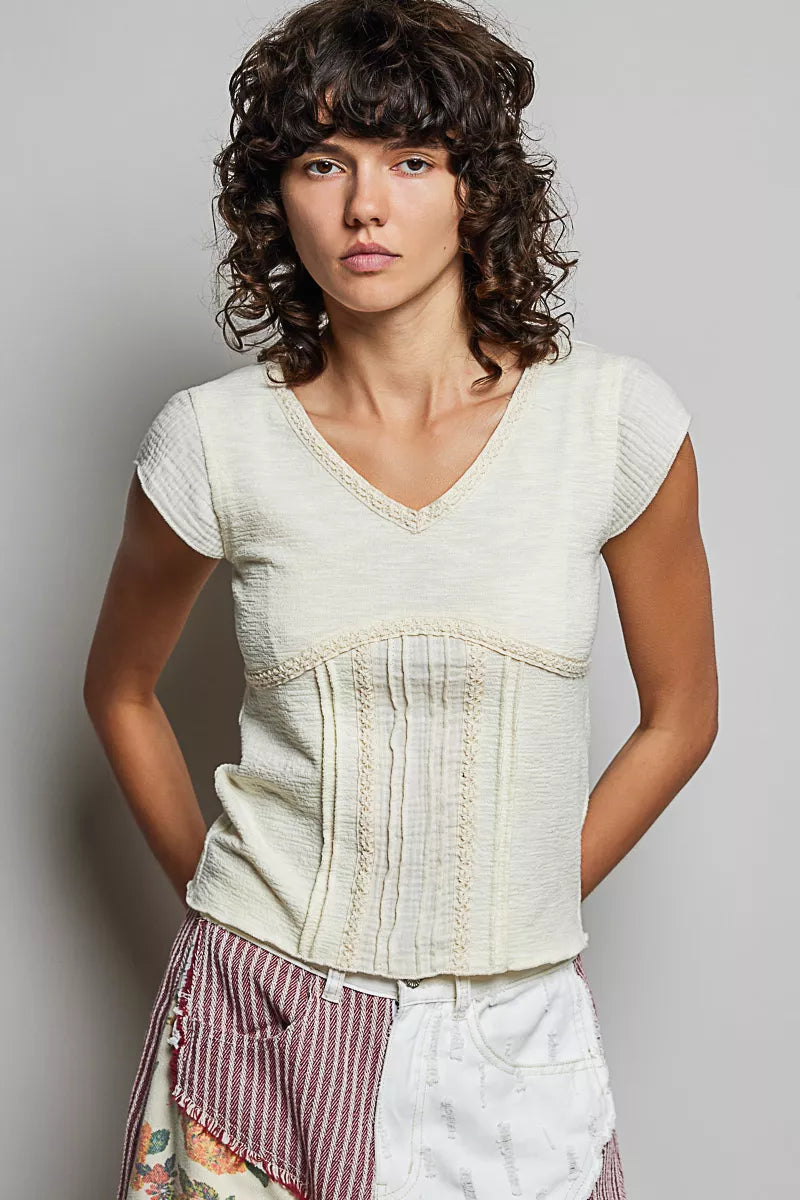 Cream lightweight V-neck knit top with lace-trimmed neckline and ruched textured front