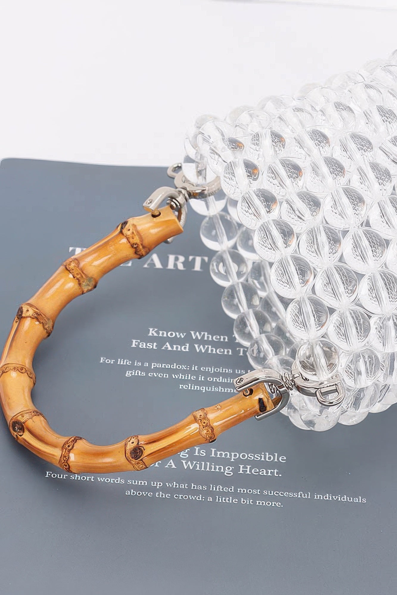 Bamboo handle and clear beaded tote bag side view with metal rings and clips