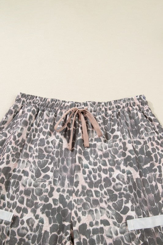 Khaki leopard print pants with elastic waistband and drawstring tie, patch pockets