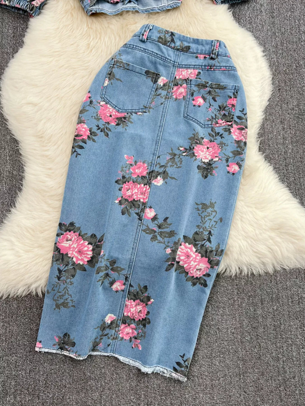 Blue floral denim skirt with front seam and two side pockets, button closure
