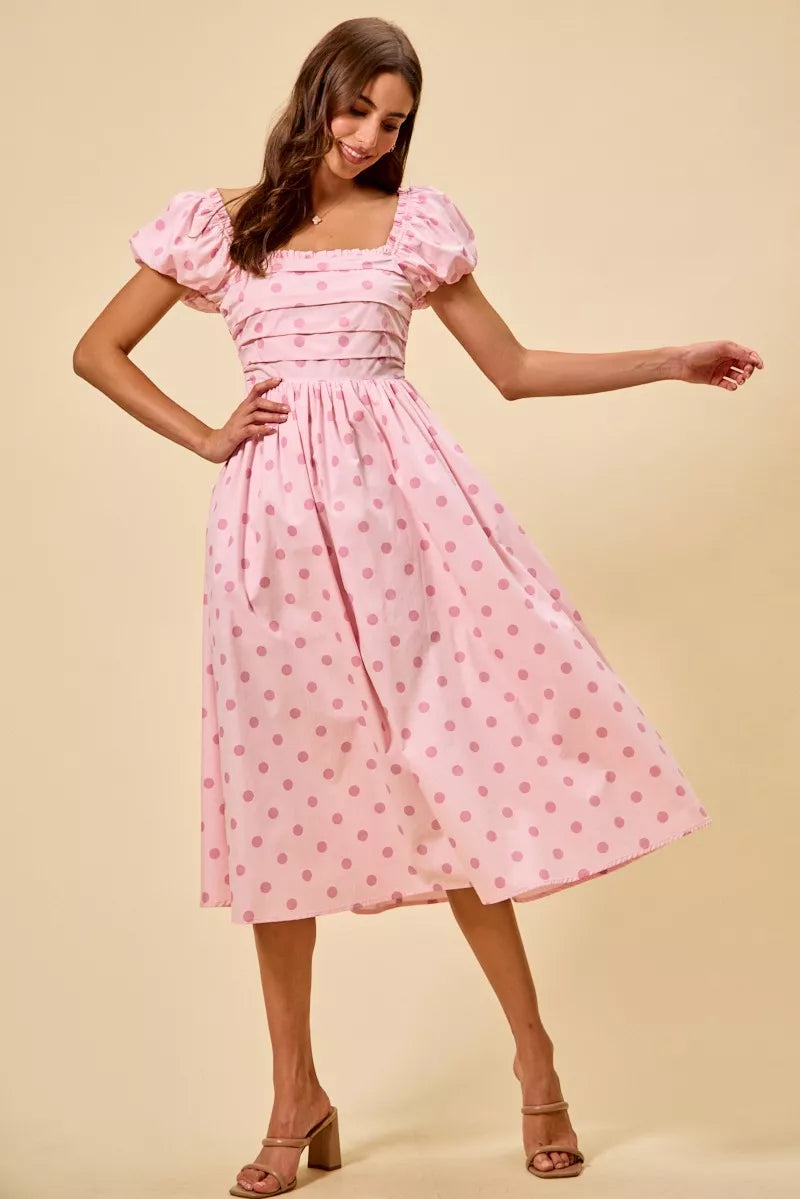 Pink polka-dot midi dress with puff sleeves, ruched bodice, and flared skirt