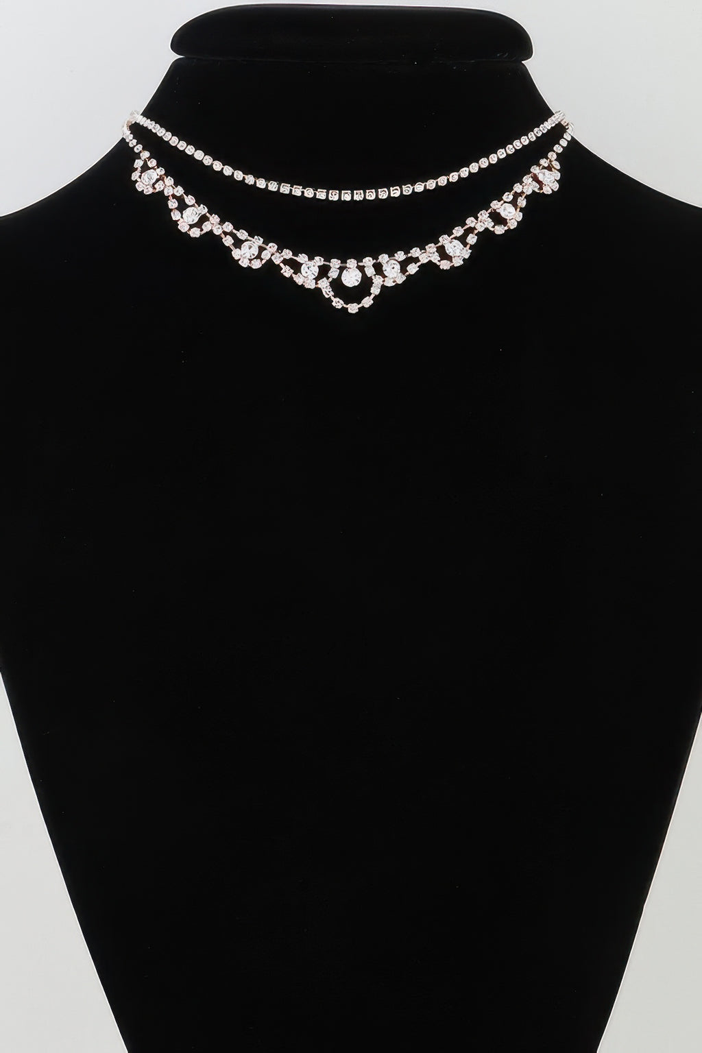 Silver rhinestone layered drop necklace on black bust
