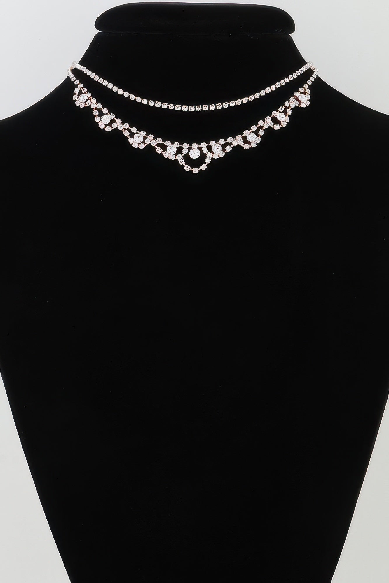 Silver rhinestone layered drop necklace on black bust