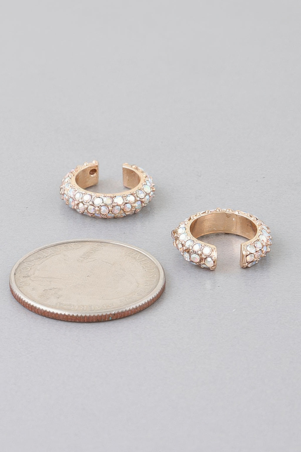Gold-tone ear cuff with clear stones, curved open band and snap-back posts