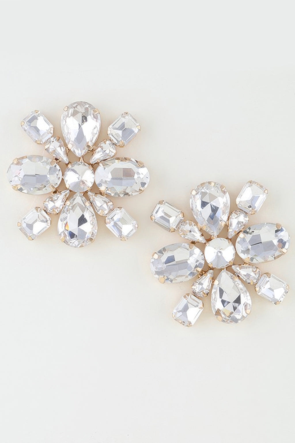 Clear rhinestone flower stud earrings with gold-tone settings and faceted oval stones