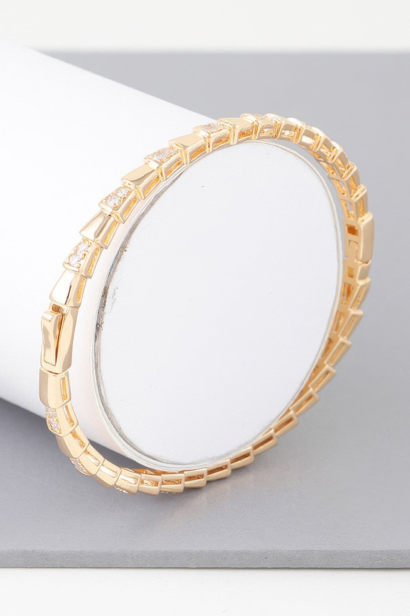 Bejeweled snake scale bracelet in gold, hinged oval cuff with clear stones