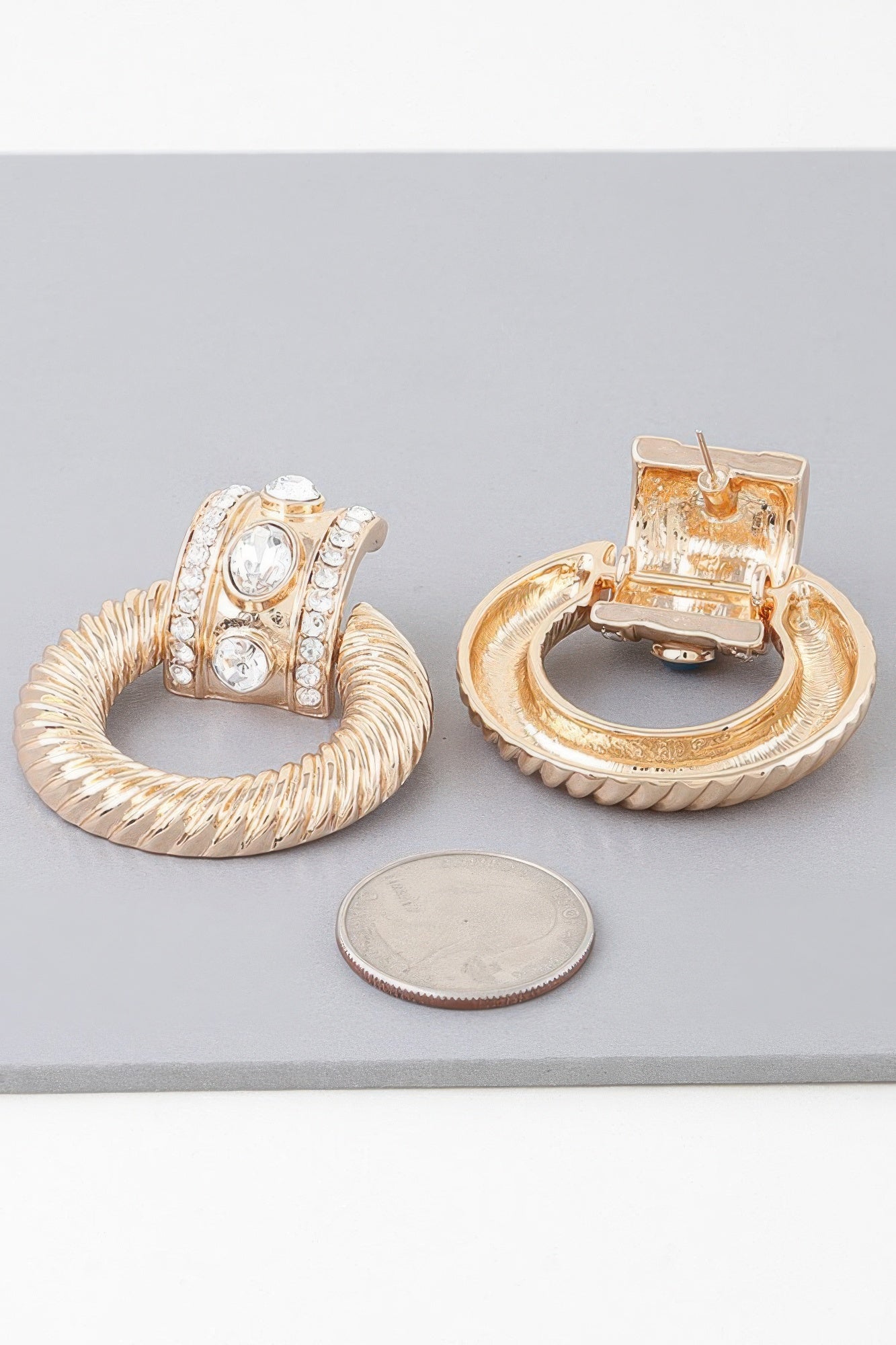 Gold clear twisted hoop drop earrings with crystal-clear center stones in twisted hoops