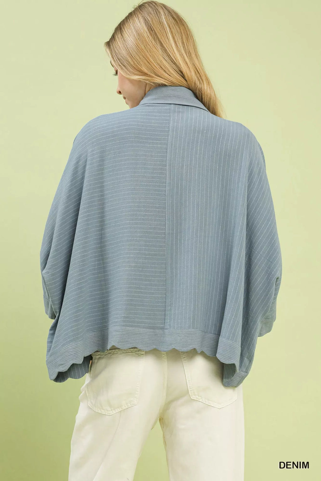 Back view of oversized denim striped button-down shirt with wide cape sleeves