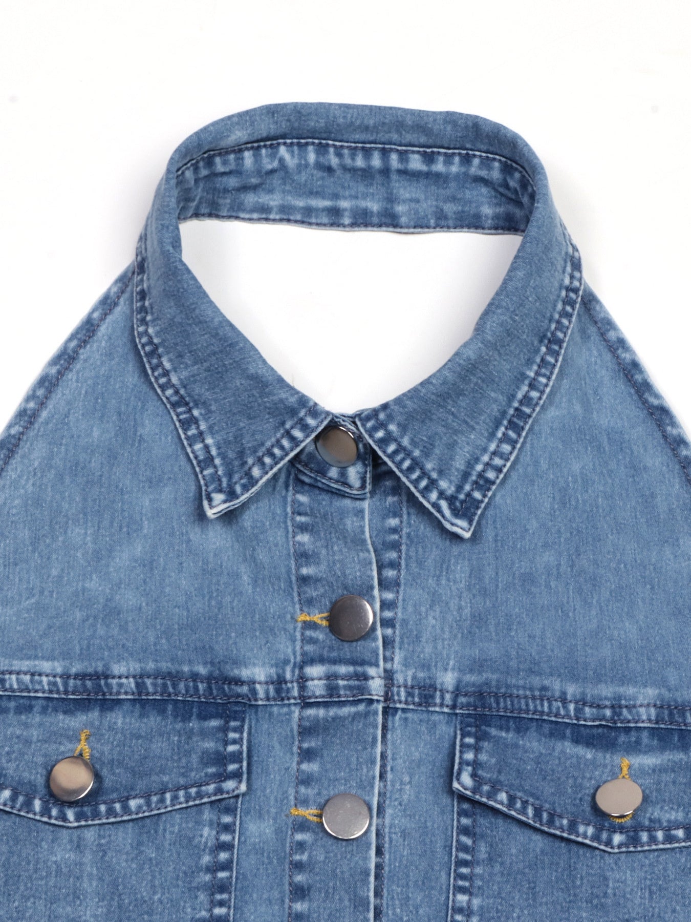 Close-up of halter neckline and front buttons on light blue denim dress
