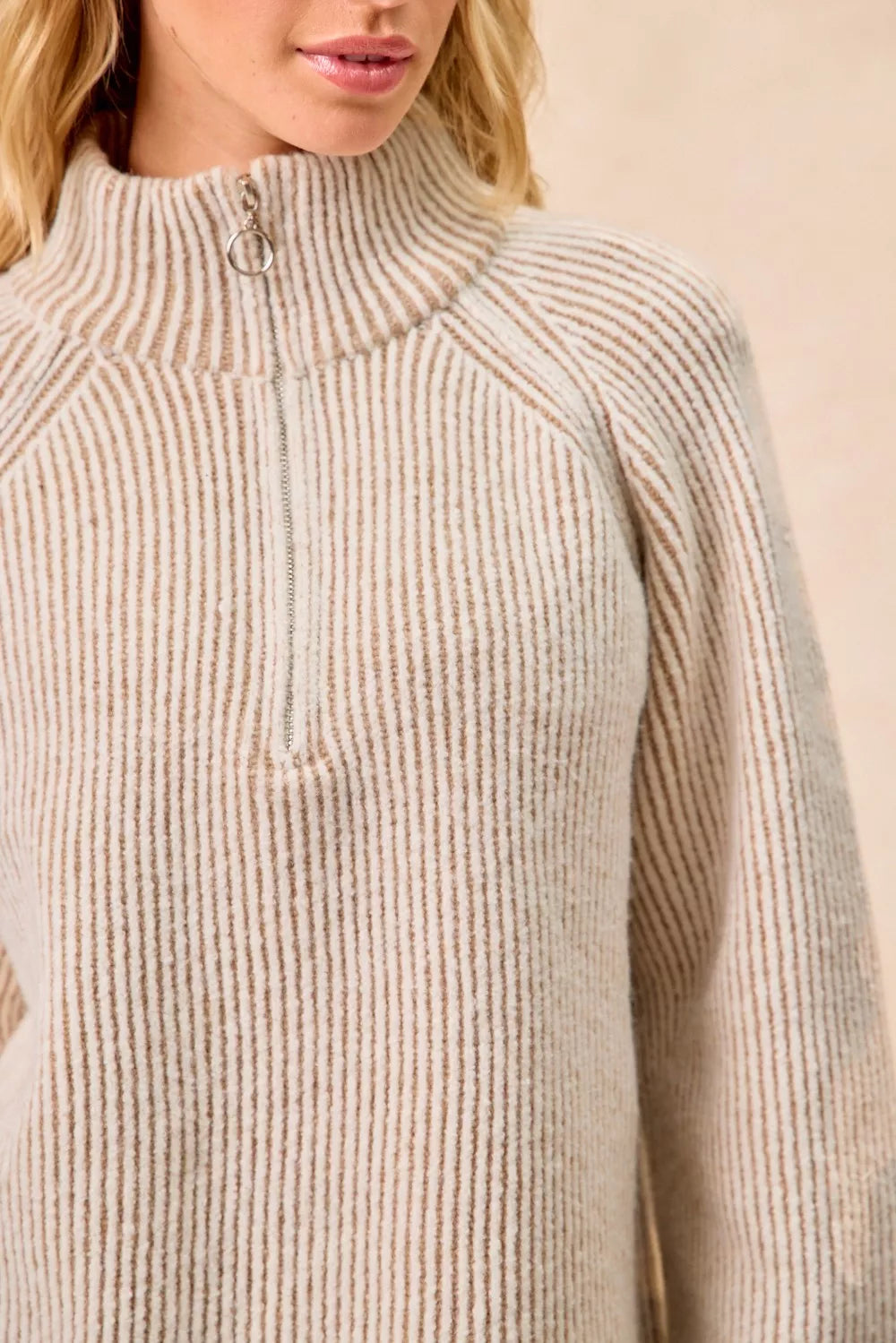 Taupe ribbed knit top with stand collar and half-zip, close-up of zipper