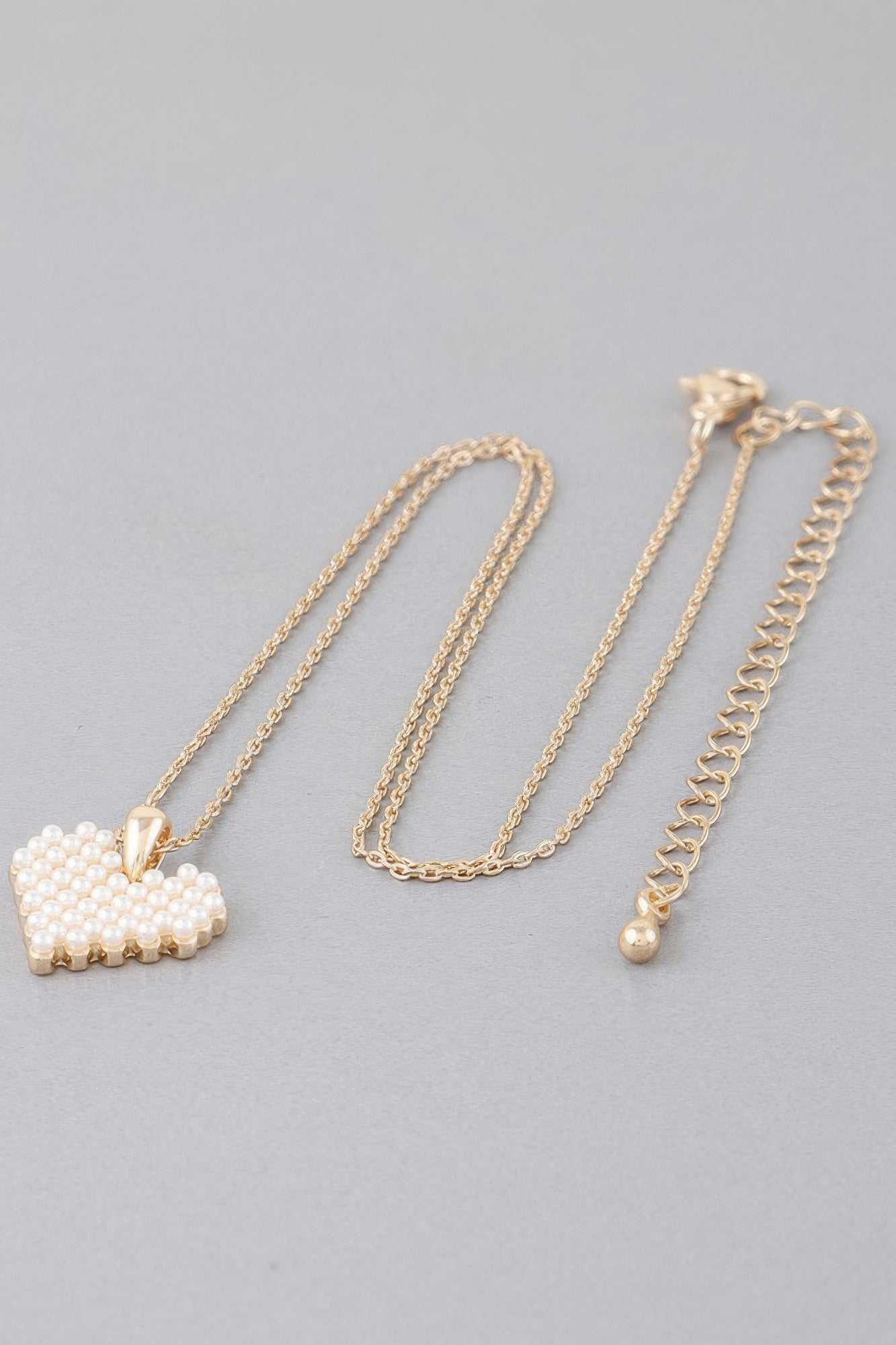 Gold-tone chain necklace with pearl block heart pendant and clasp