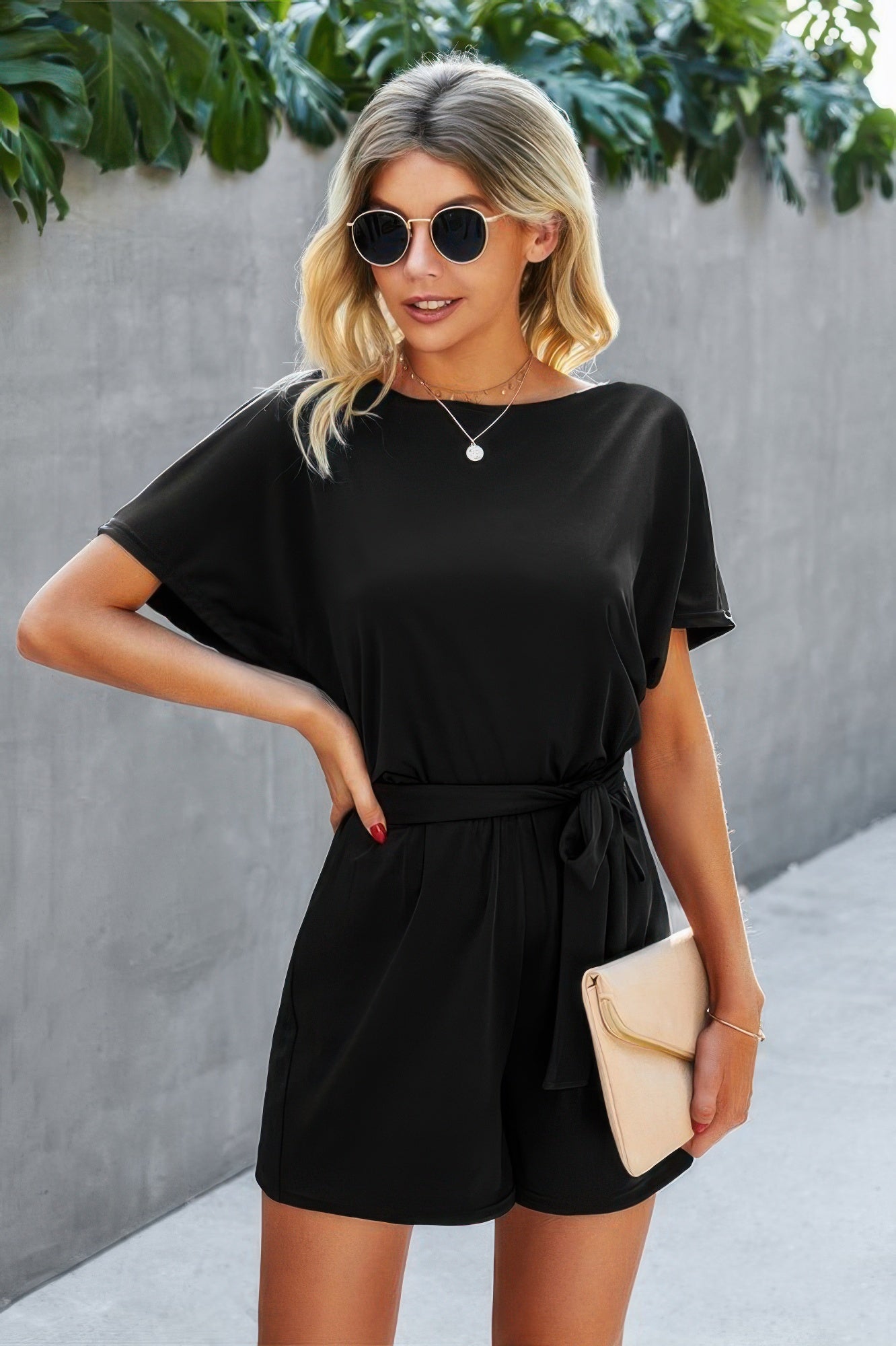 Black boat-neck romper with waist tie at elastic waist, short loose legs