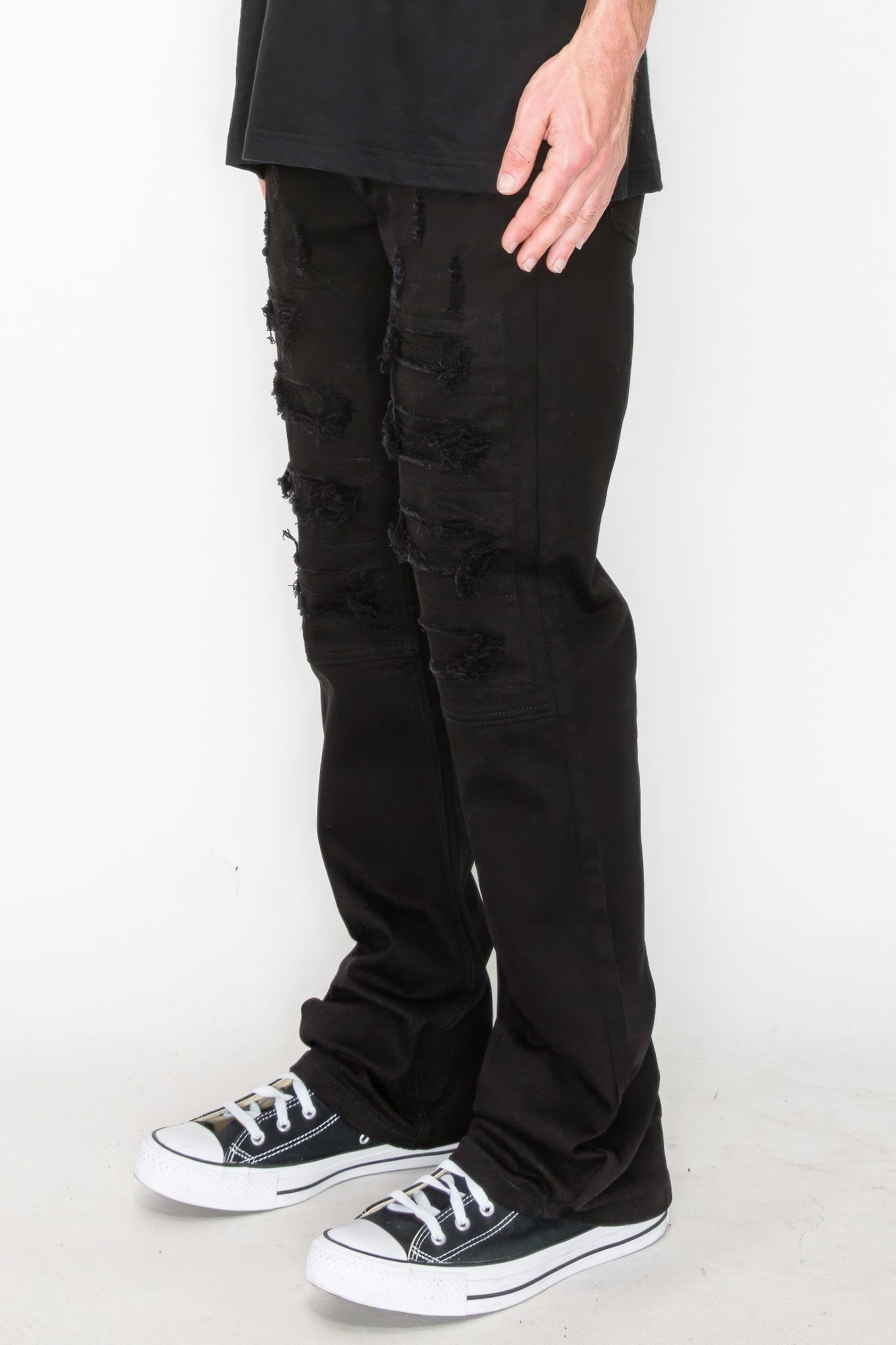 Bootcut jeans in black with front rips and stitched repair patches on the thighs