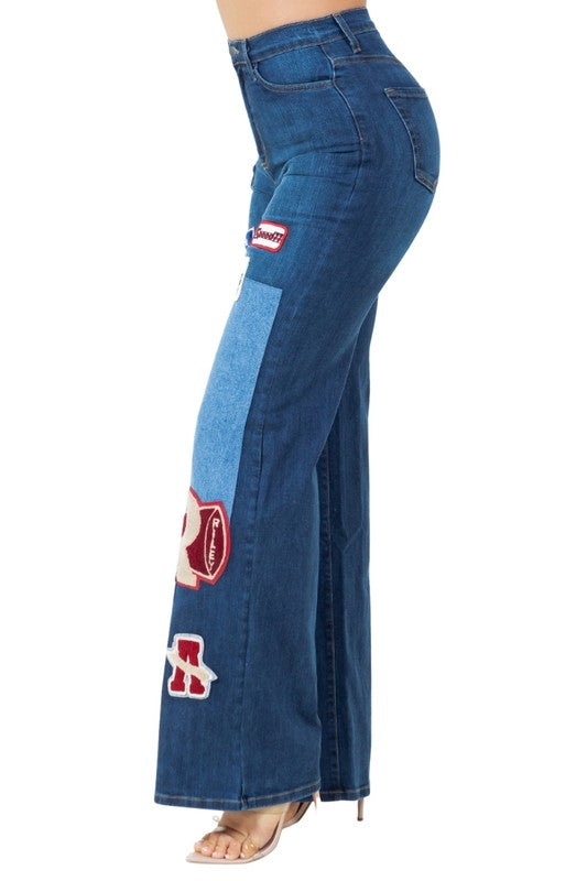 Dark wash denim jeans, side view with patch appliqués and wide flare leg
