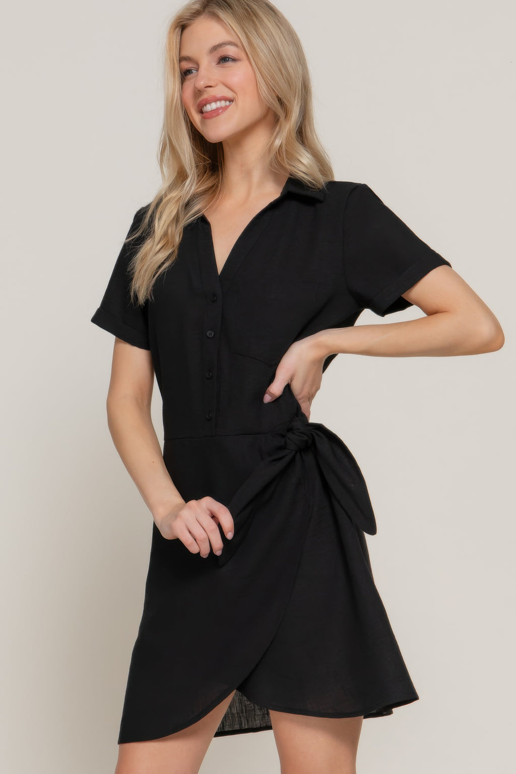 Black mini dress with front buttons and gathered side bow at waist