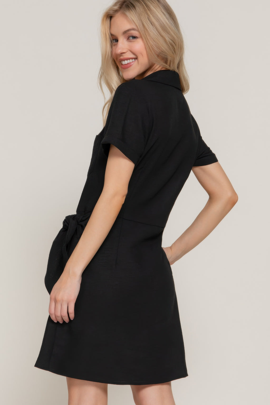 Black mini dress from side/back, waist side bow detail, short sleeves