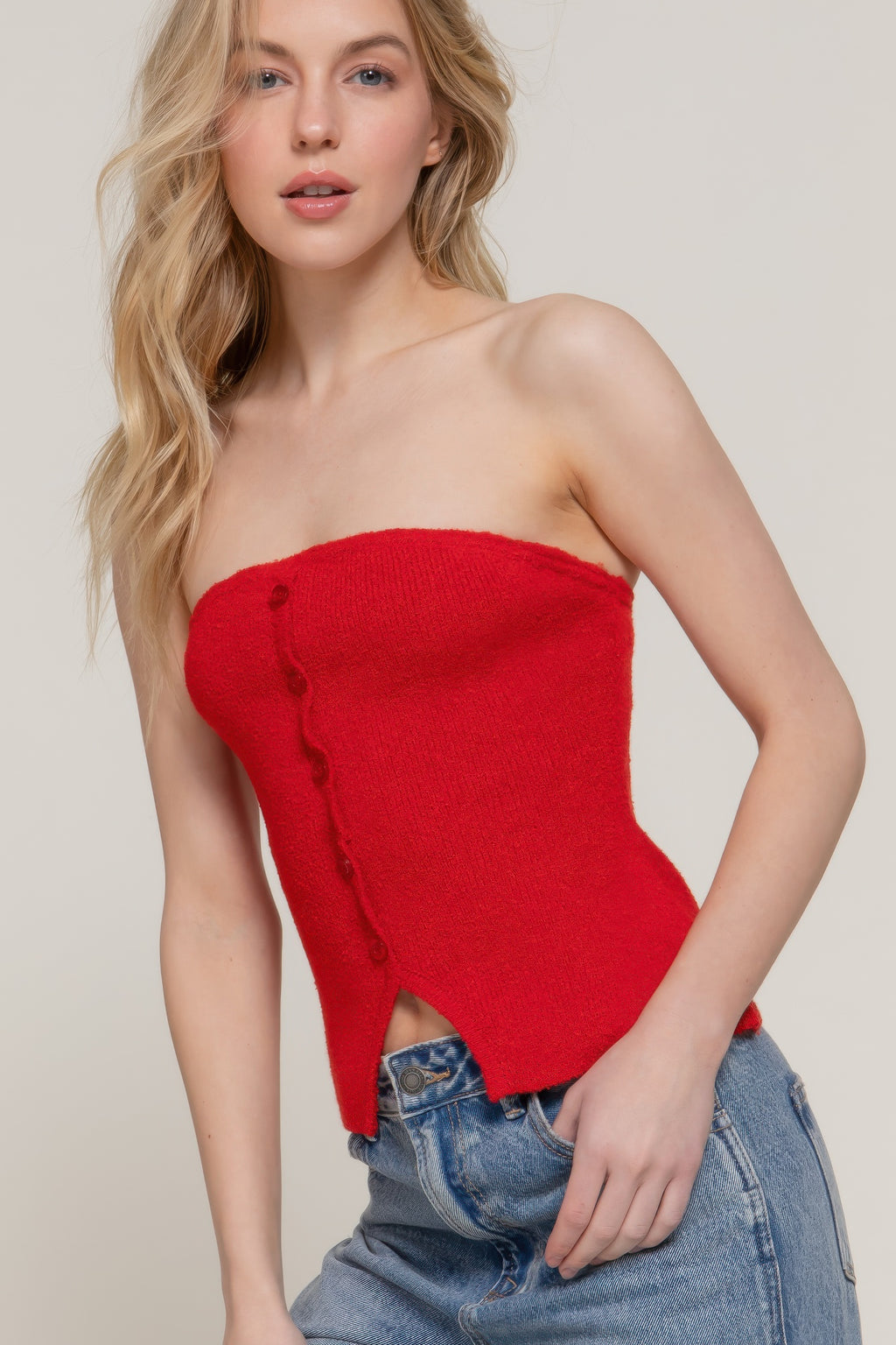 Red strapless sweater with front buttons and curved side opening near hem