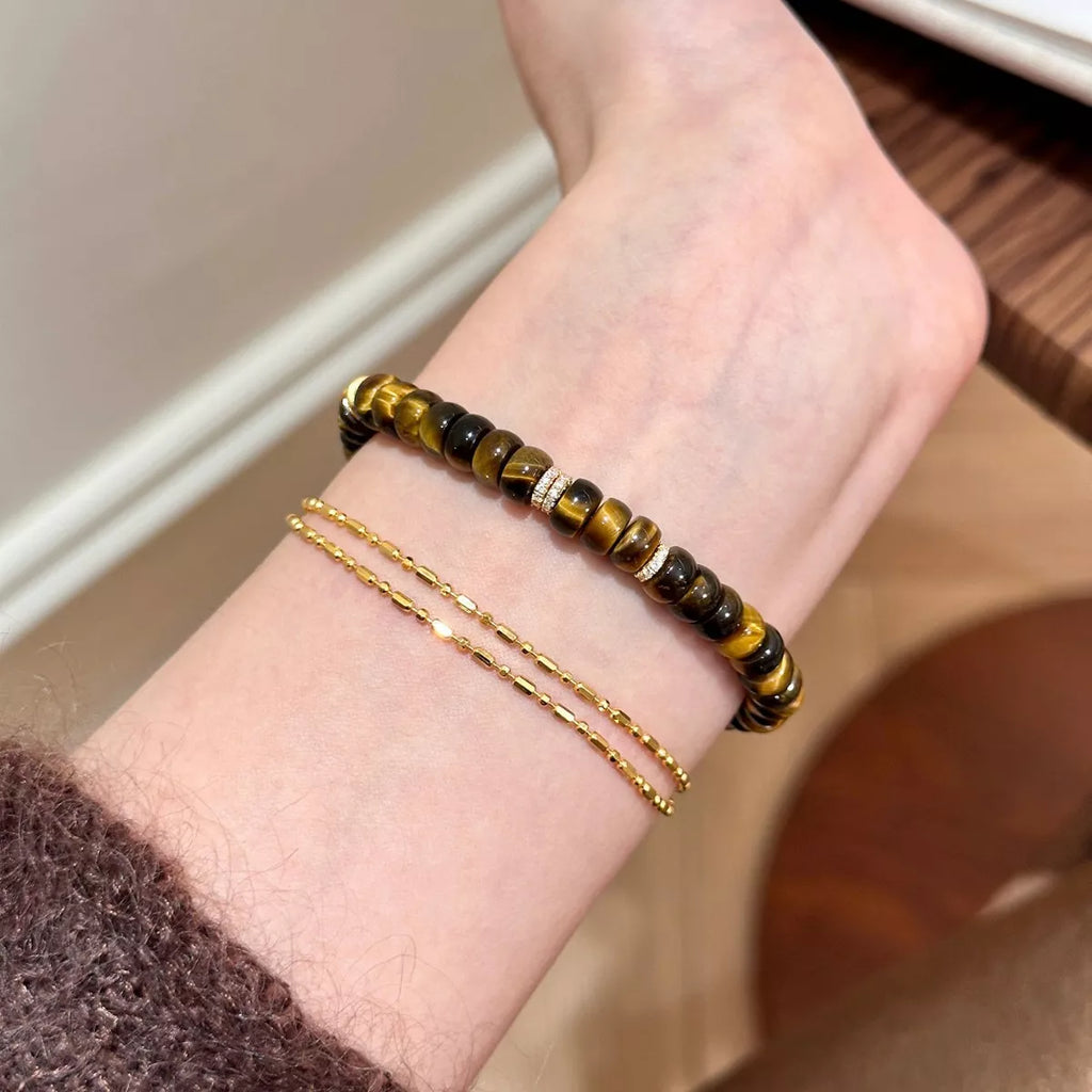Tiger's Eye beaded bracelet on wrist, stacked brown and black beads with shine