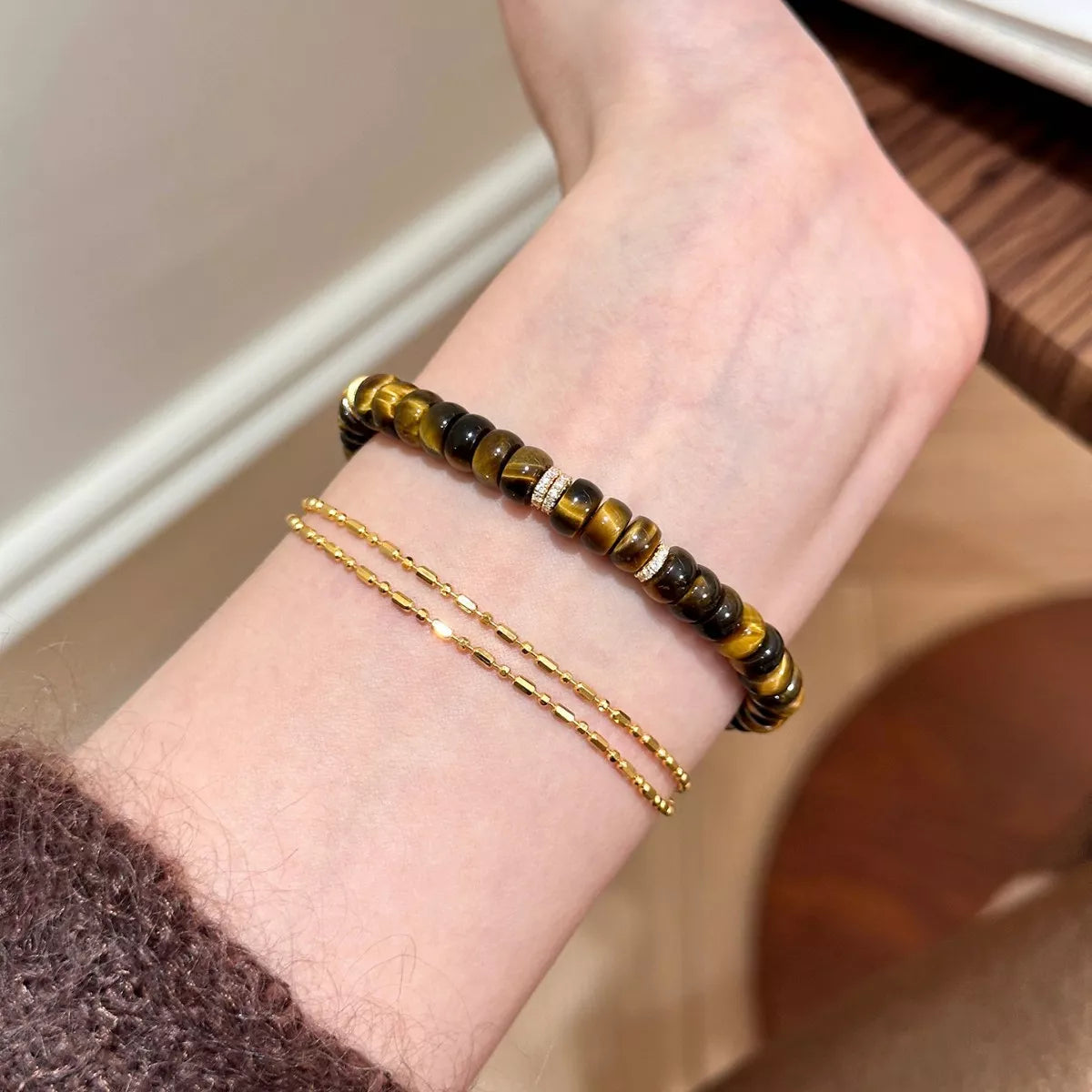 Tiger's Eye beaded bracelet on wrist, stacked brown and black beads with shine