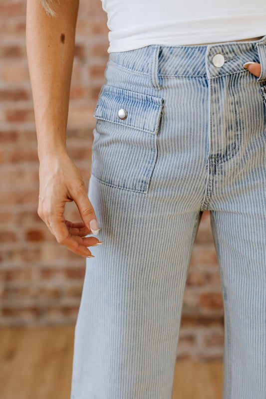 Sky blue stripe jeans close-up: front pockets, button closure, and button-fly waistband
