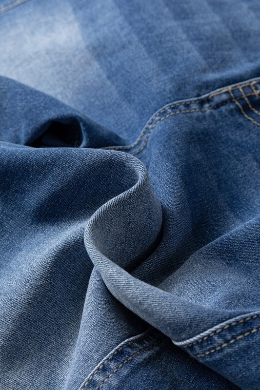 Denim fabric close-up with wash texture and stitched seam