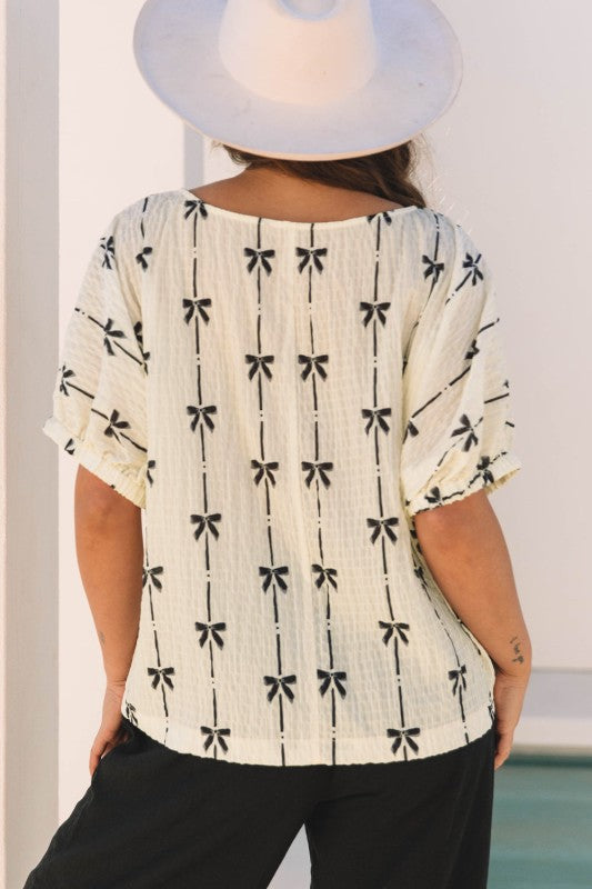 Bow-texture short puff sleeve top, black bow and stripe print on cream, crew neckline
