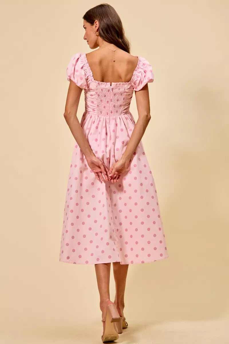 Back view of pink polka-dot midi dress with ruched square back and puff sleeves