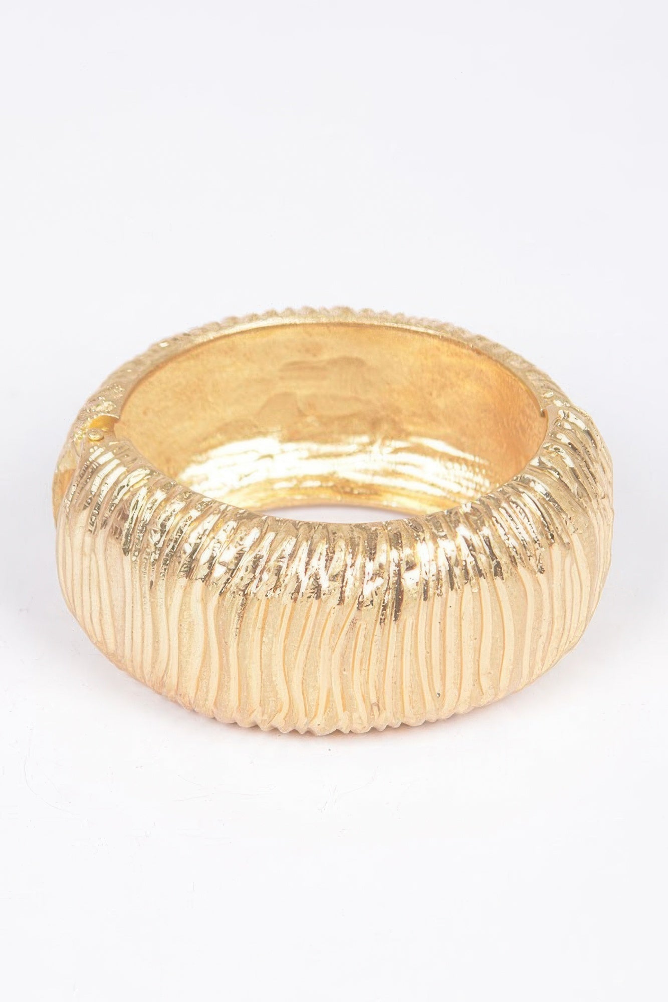 Gold cast metal spring hinge cuff bracelet with ridged texture