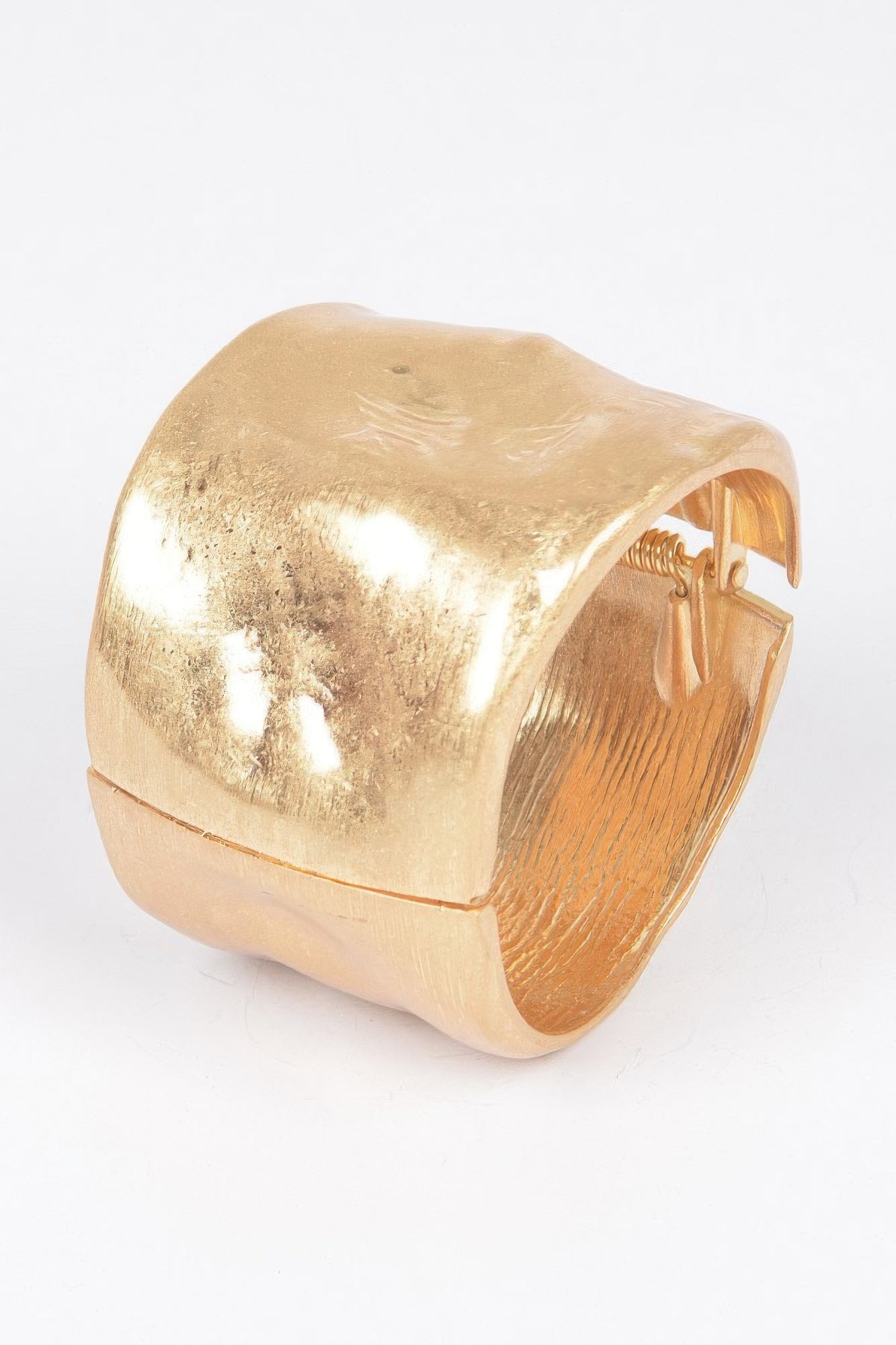 Gold cuff bracelet with spring hinge detail, reflective hammered finish