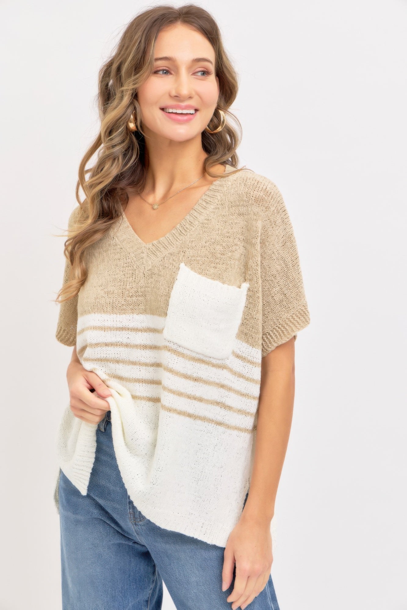 Taupe oversized knit sweater with V-neck, short sleeves; white chest pocket and stripes