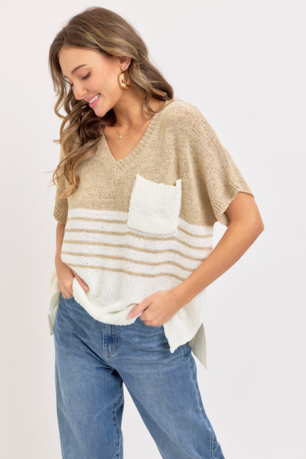 Taupe oversized knit top with V-neck; white pocket, horizontal stripes, and relaxed fit