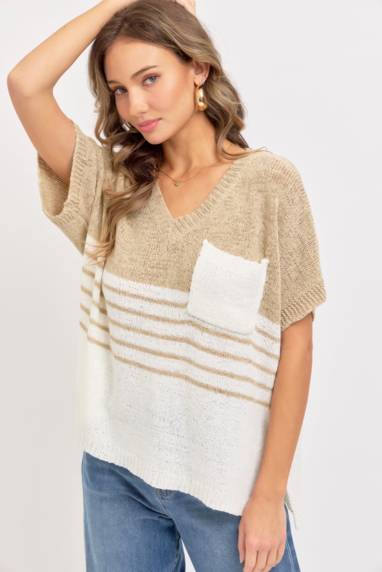 Taupe oversized knit sweater with V-neck and short sleeves; white pocket and stripe band