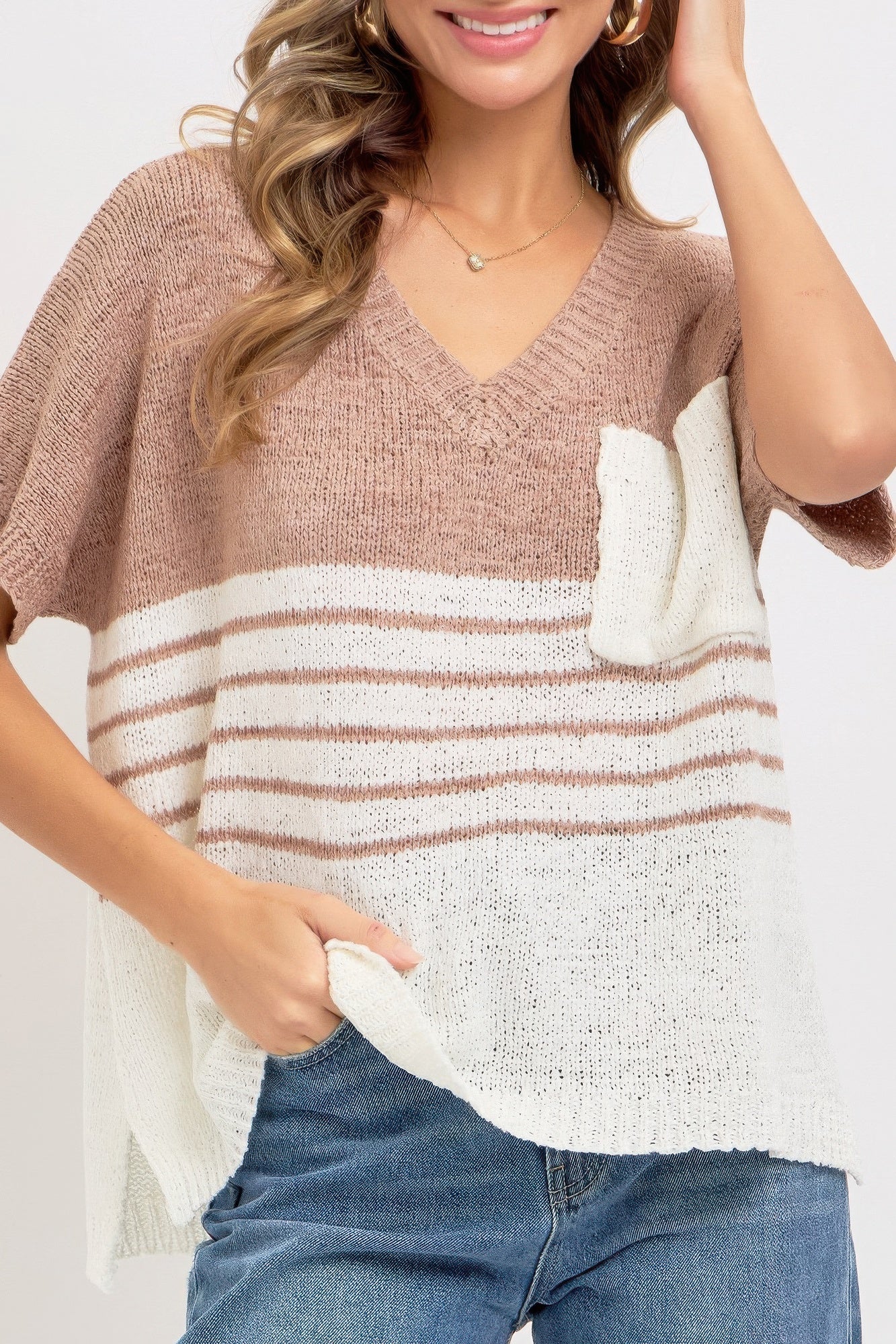 Oversized knit top close-up: taupe upper, cream front panel with rust-white stripes