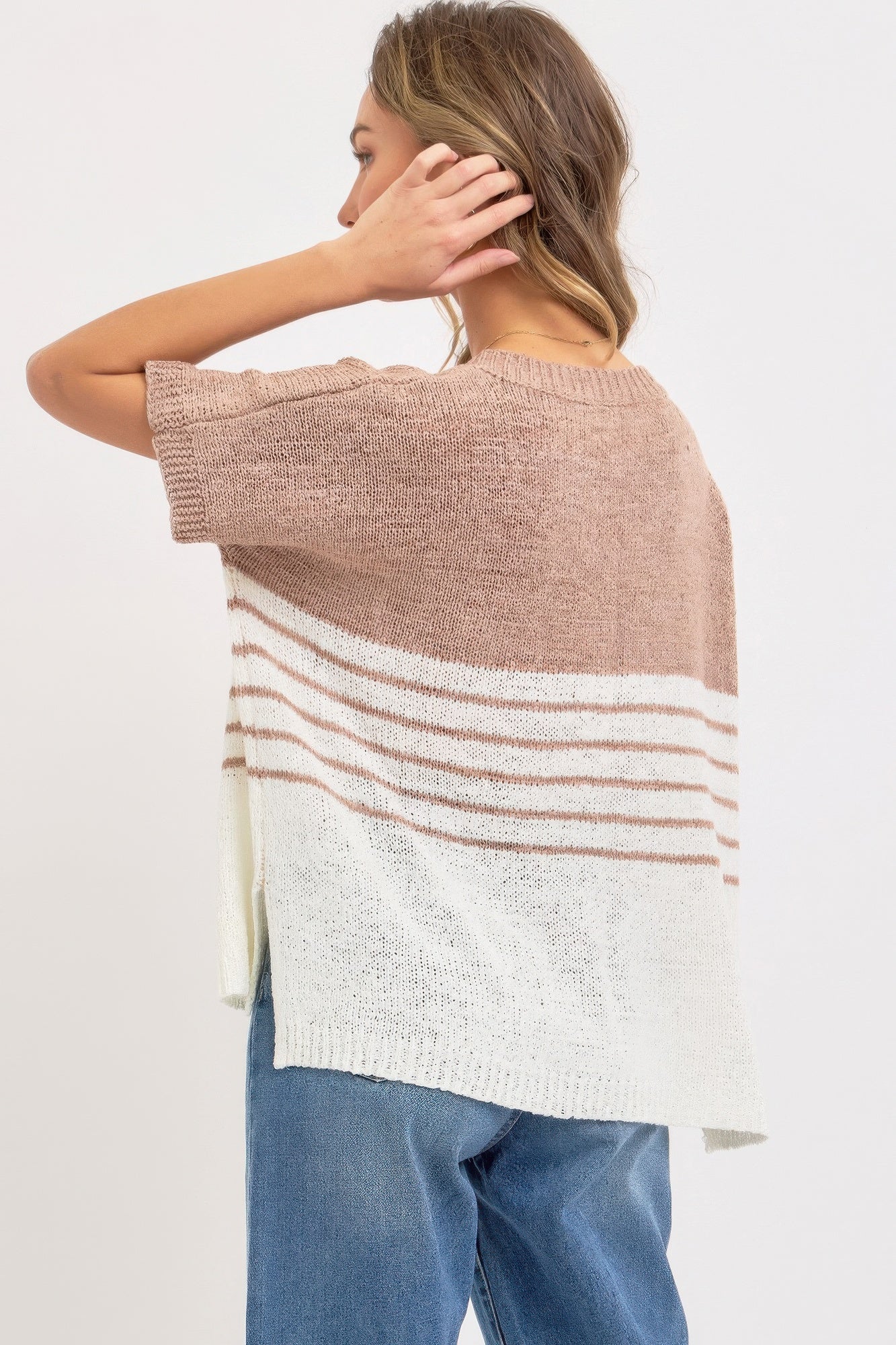 Back view of oversized knit top: taupe yoke, cream body with horizontal stripe panel