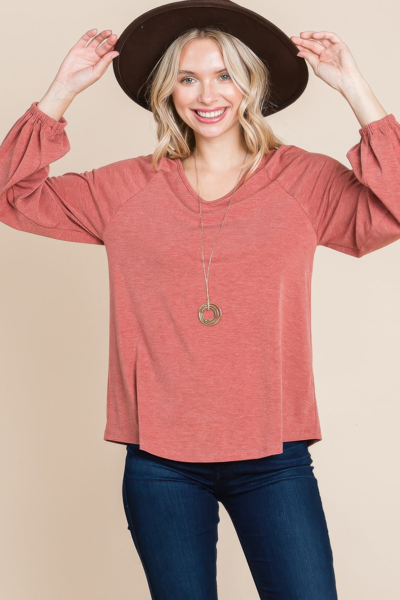 Rust V-neck long-sleeve top, loose fit with cuffed sleeves at wrists