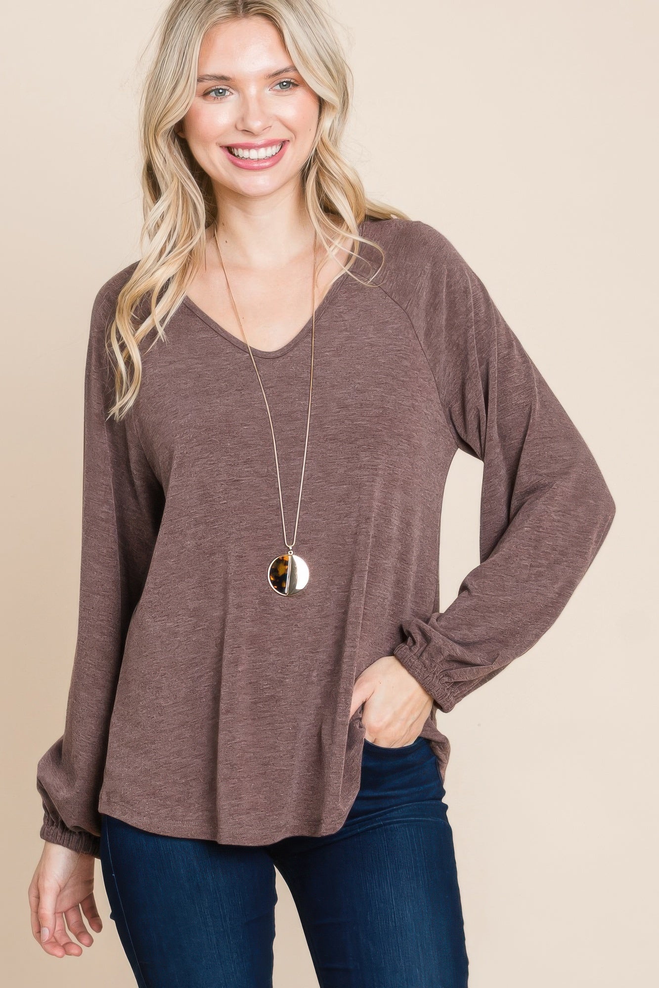 Dark brown V-neck long sleeve top with loose fit and ruched cuff detail