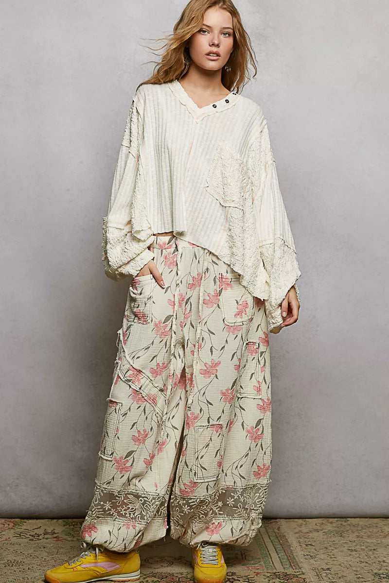 Off-white long-sleeve V-neck top with button placket and pocket stitching
