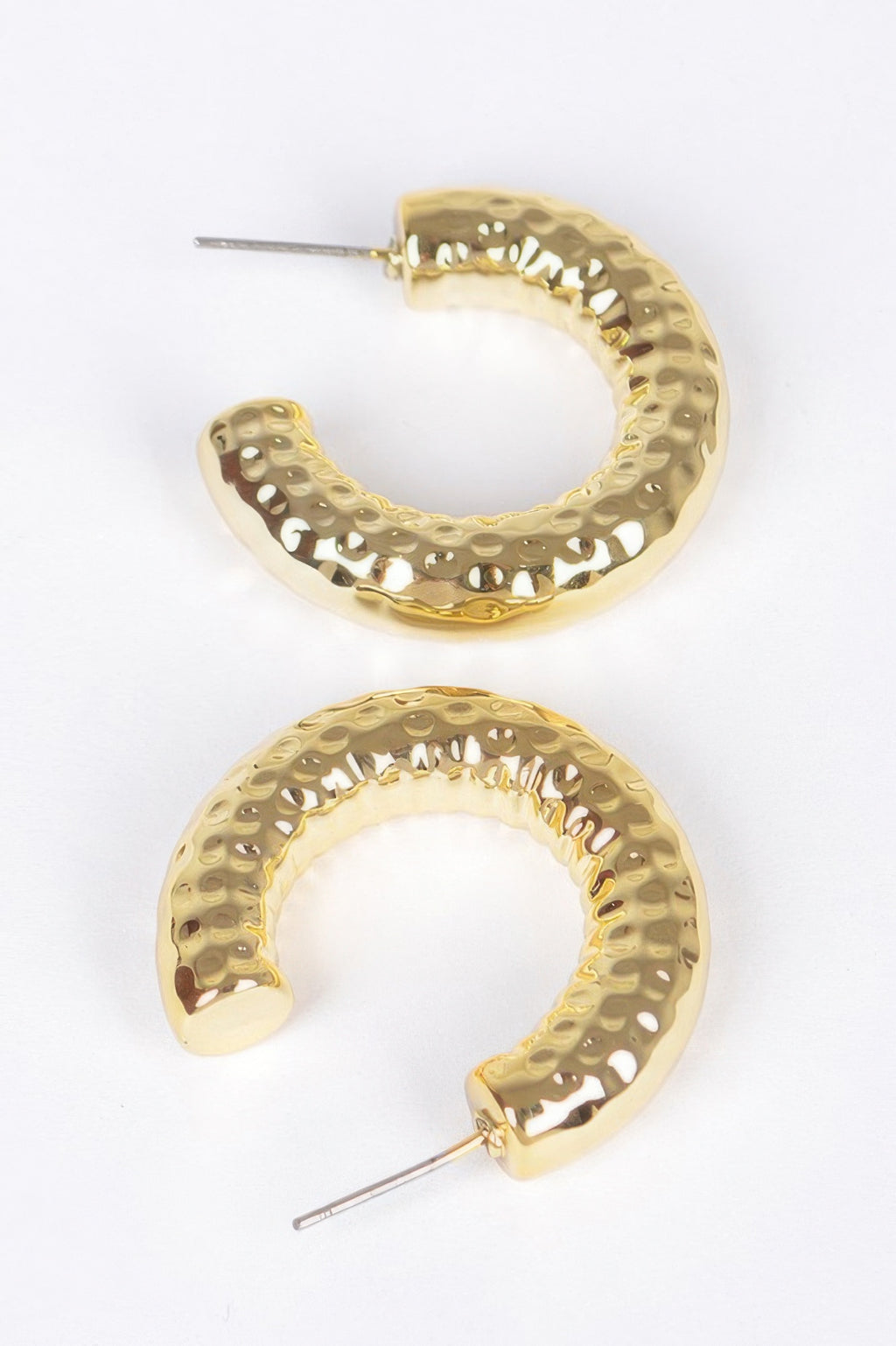 Gold hoop earrings, textured curved band with stud fasteners; close view