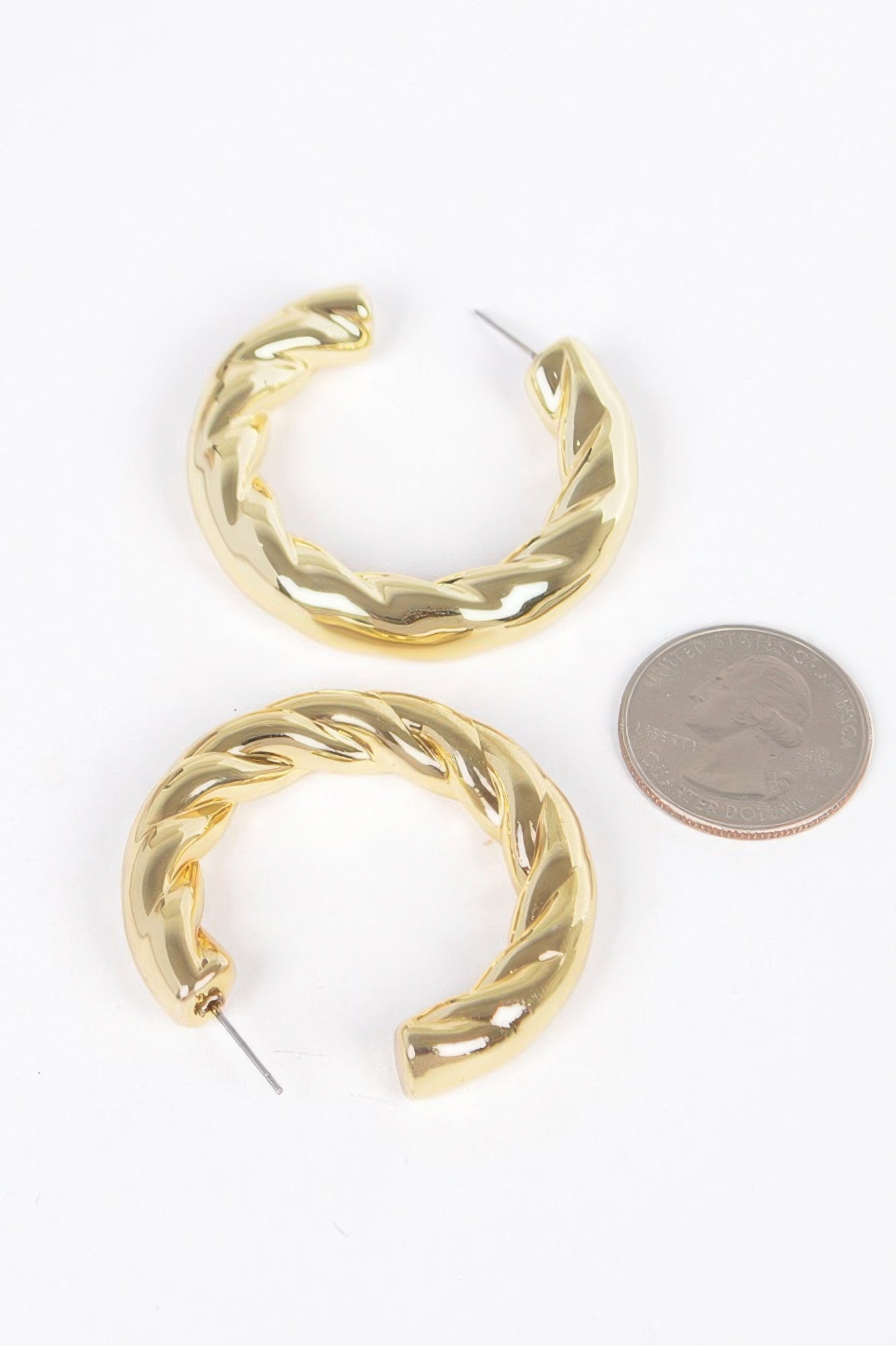 Gold CCB hoop earrings, twisted oval hoop; shown with coin for size