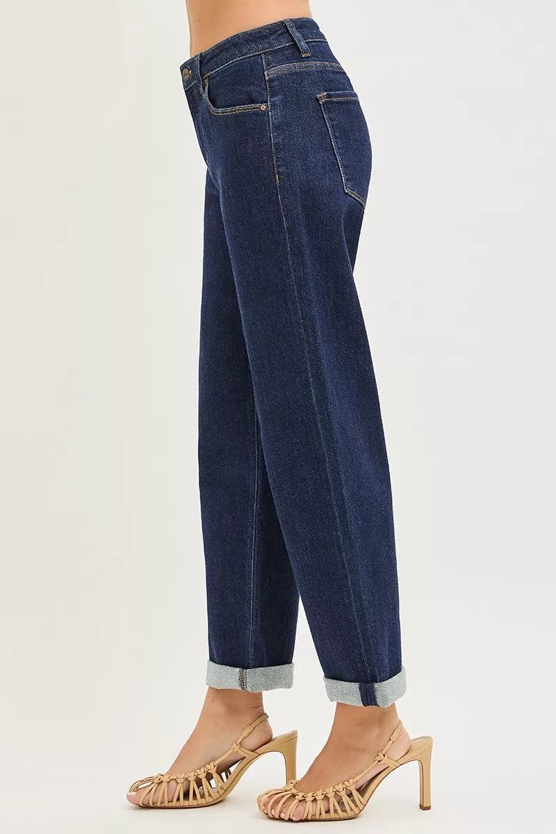 Dark blue boyfriend jeans, side view with cuffed hem and front button/zip.