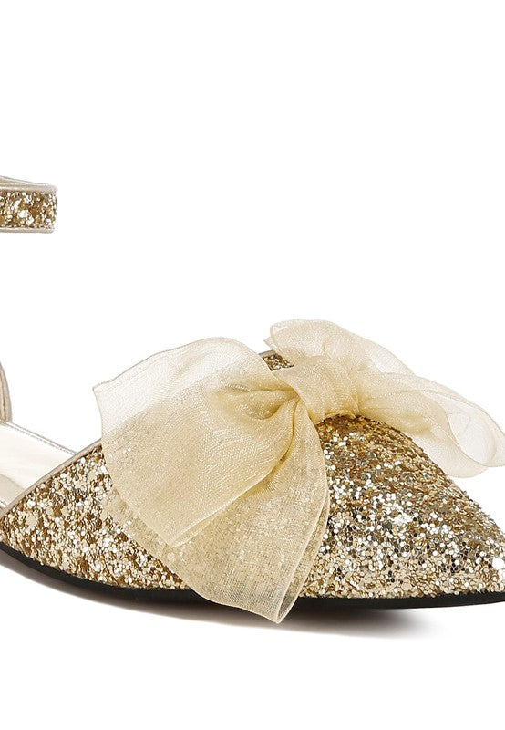 Close-up of gold glitter flat sandal with sheer bow over the pointed toe