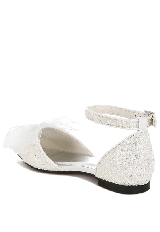 Weiße Glitzerflat-Sandalen von der Seite: T-Riemen, Tüllschleife vorn, flacher Absatz