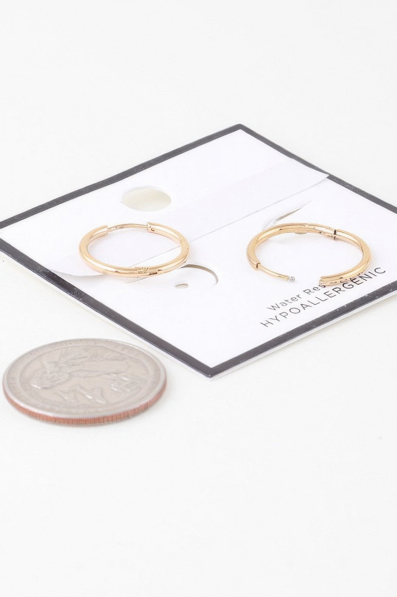 Gold hoop earrings set on jewelry card, slim round hoops with hinge closure