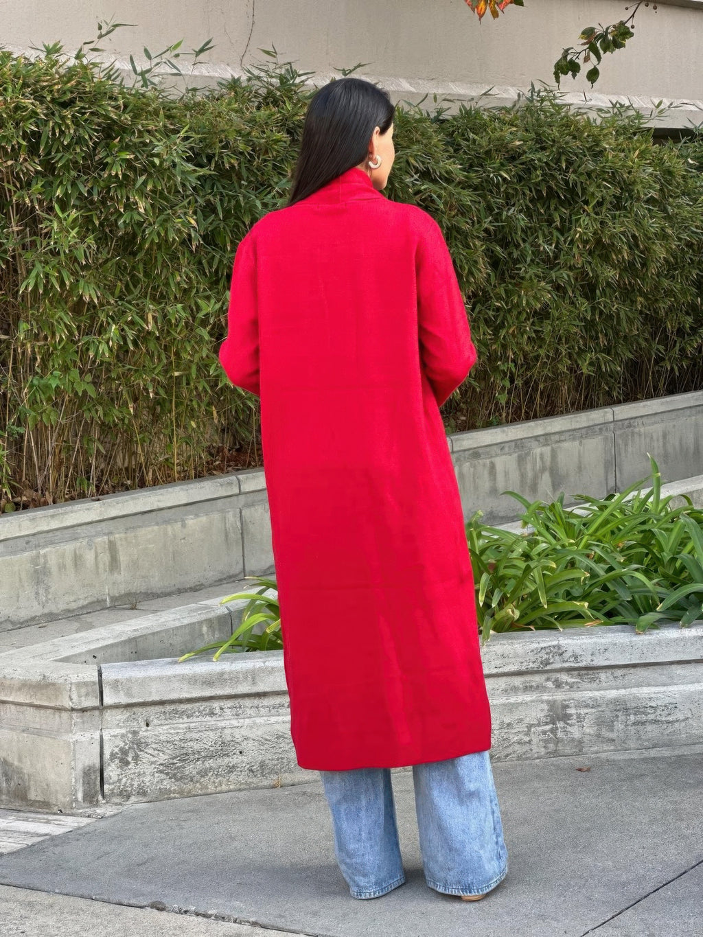 Back view of red midi cardigan with pockets and long sleeves, open front