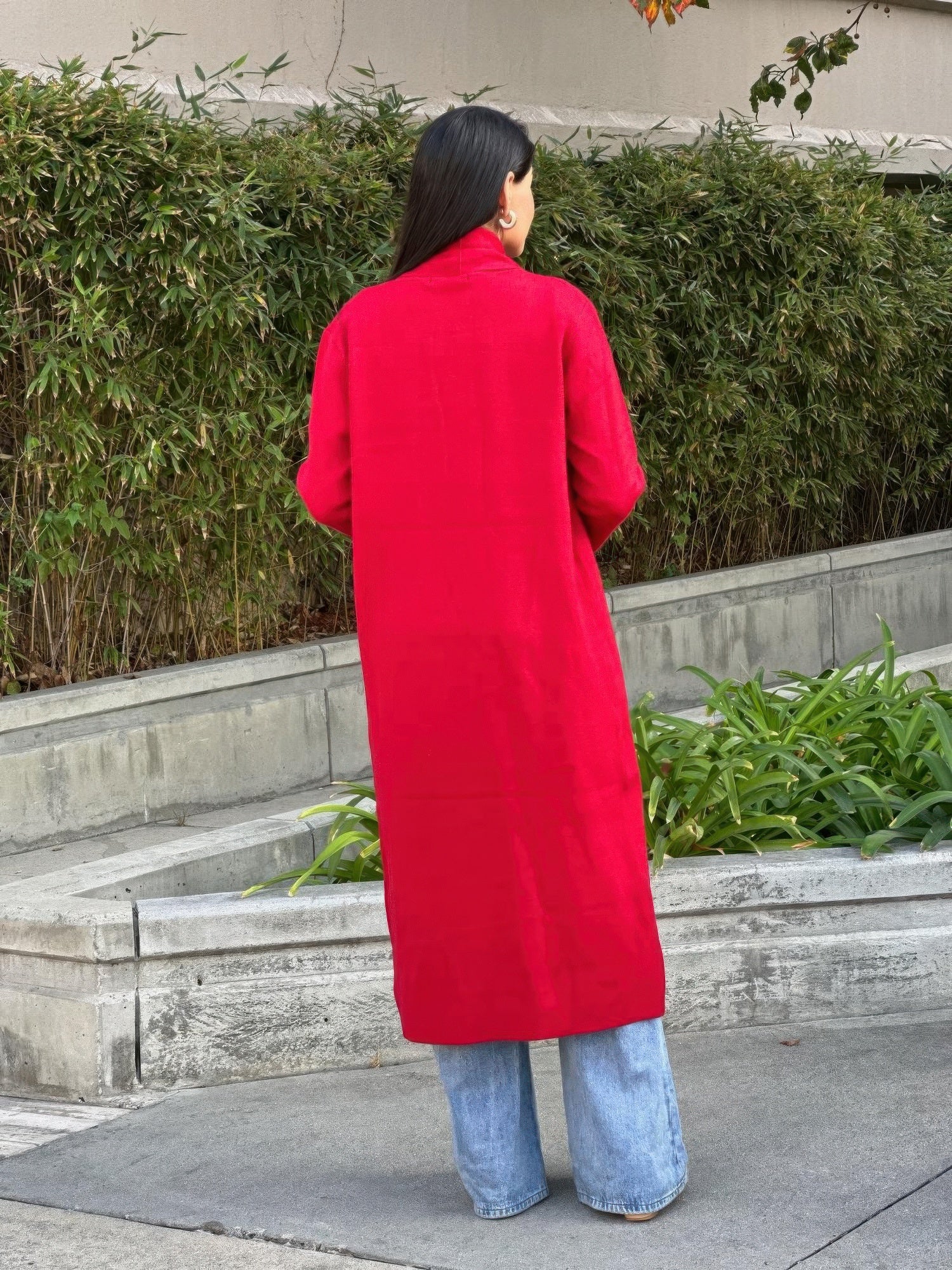 Back view of red midi cardigan with pockets and long sleeves, open front