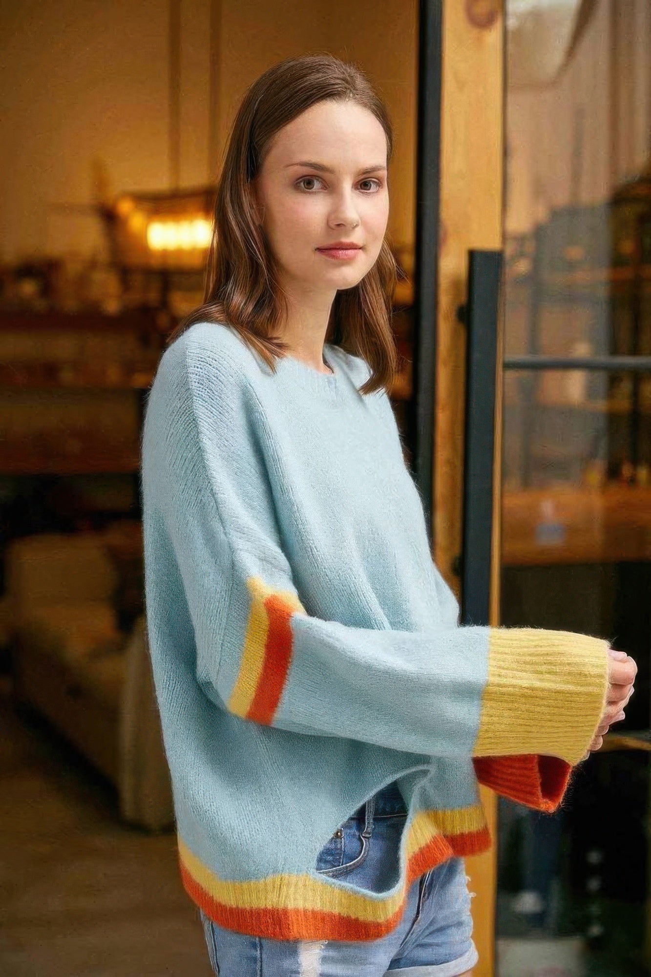 Farbenblock-Pullover hellblau, Ärmelbündchen und Saum gestreift in gelb und orange