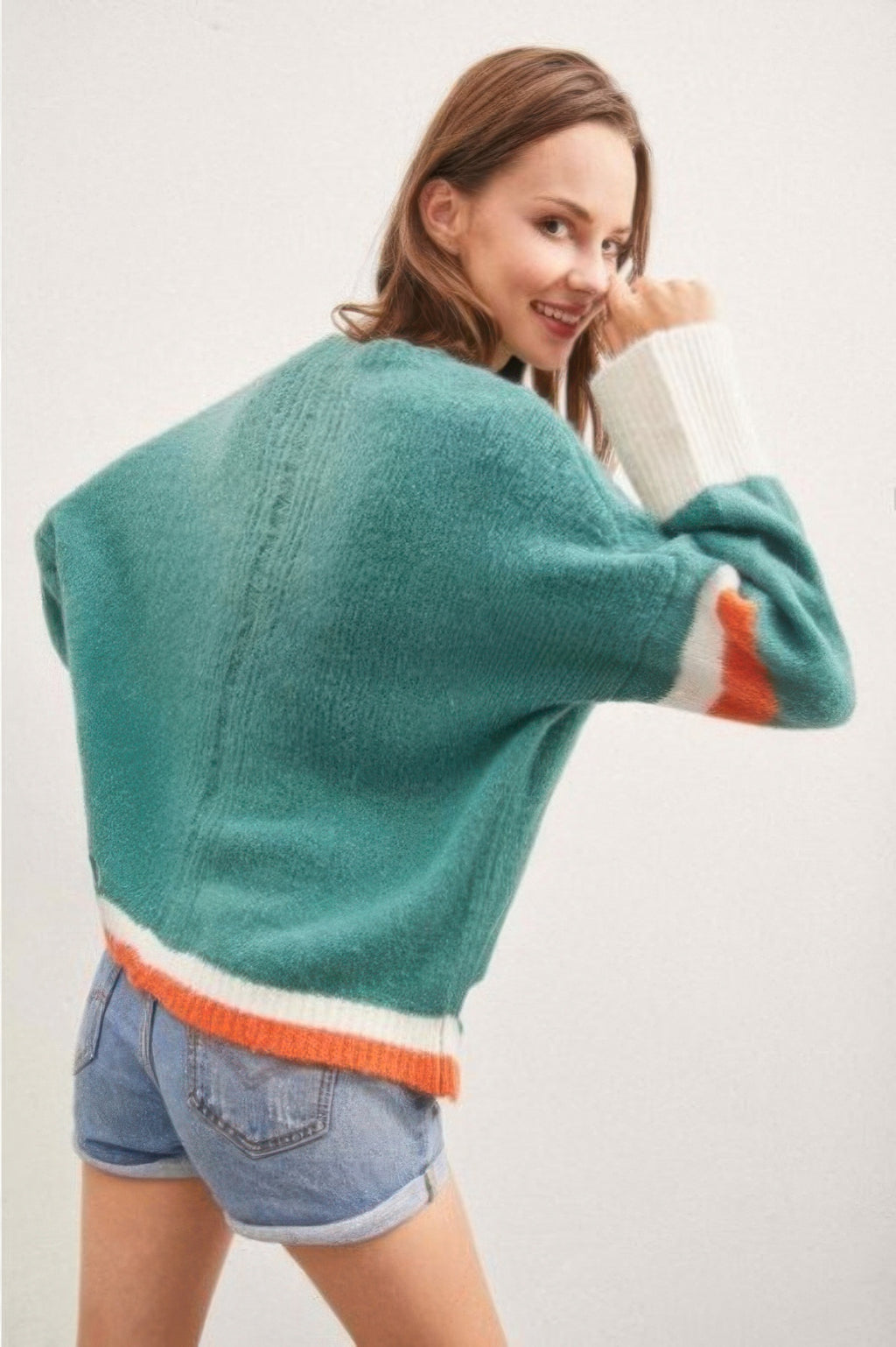 Back of teal color-block sweater with white/orange hem stripe